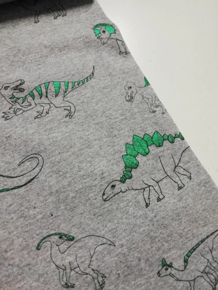 Bavlněný úplet vzor dinosauři na šedé