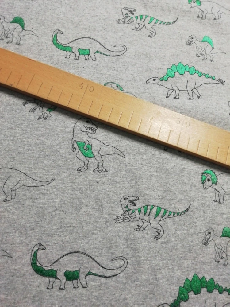 Bavlněný úplet vzor dinosauři na šedé
